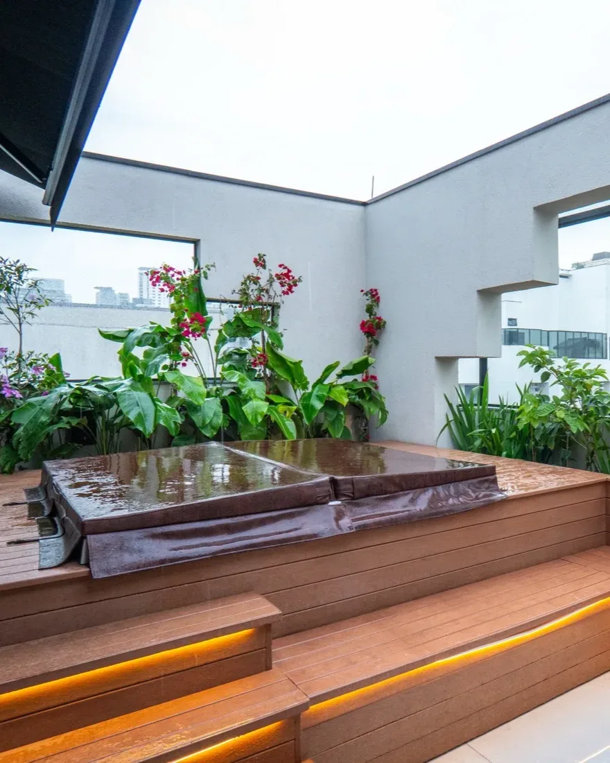 Projeto Bougainvillea — banco do terraço com iluminação embutida e floreiras floridas