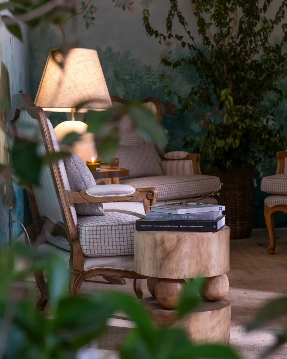 Jardim de Inverno · CasaCor 2025 — poltrona e mesa de tronco vistas por entre a folhagem nativa