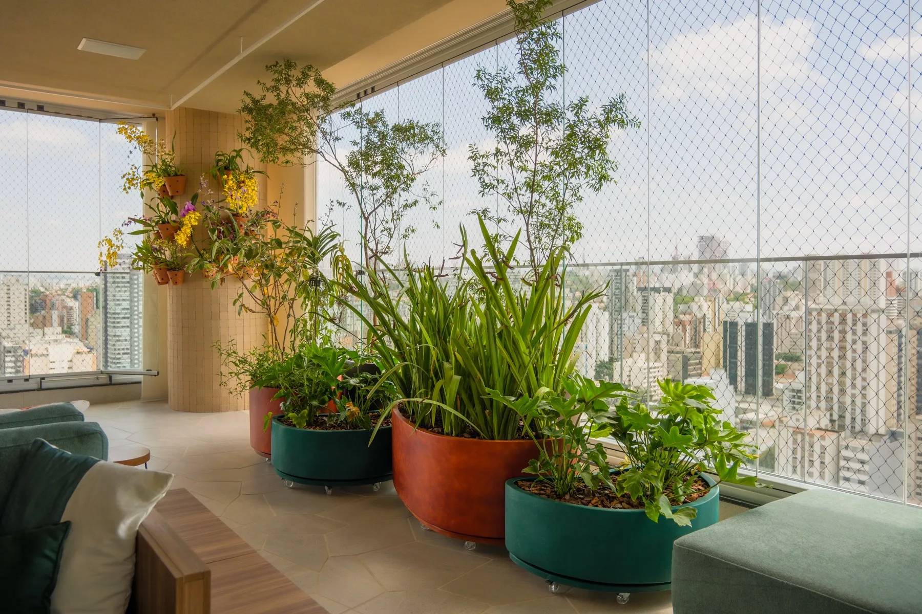 Terraço do Projeto Uvaia com vista para São Paulo, sofá e vasos com plantas nativas