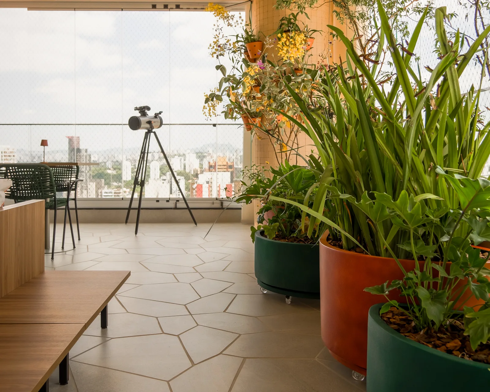 Varanda do Projeto Uvaia com vasos de plantas nativas, telescópio e vista para São Paulo